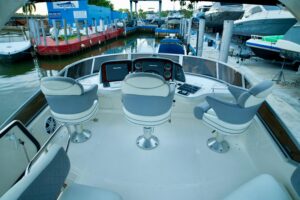 2006 Sea Ray 44 Sedan Bridge flybridge helm station with dual helm seating, steering wheel, and elevated command view over...