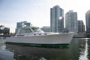 2014 Back Cove 37 cabin cruiser helm station with dual Garmin displays, leather seating, and hardtop overhead.