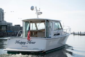 2014 Back Cove 37 cabin cruiser helm station with dual Garmin displays, steering wheel, and helm seating in pilothouse.