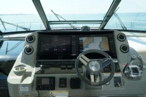 2014 Sea Ray Sundancer 540 main salon seating area with curved lounge upholstery, interior cabinetry, and ambient cabin li...