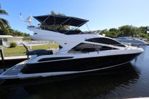 2016 Sunseeker Manhattan 55 salon with cream upholstered seating, glass windows, and ambient lighting overlooking the water.
