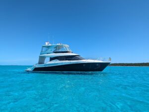 Tiara Yachts F53 Flybridge helm station with dual Garmin displays, leather helm chair, and forward visibility through wind...