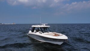 Boston Whaler 350 Realm center console helm with dual Garmin displays and helm seating overlooking the windshield.