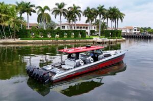 Nor-Tech 50 Sport center console helm with dual Garmin displays, leather helm seat, and hardtop overhead.