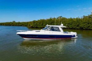 2023 Intrepid 438 Evolution 45-foot center console yacht underway on open water, full starboard profile showing hardtop, o...