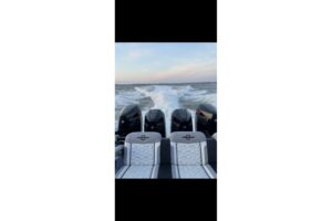 Helm station of 2024 Fountain 38 SC center console with dual Garmin displays, steering wheel, and throttle controls overlo...