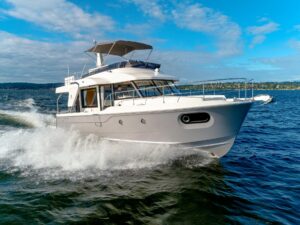 Beneteau Swift Trawler 41 Fly helm station with dual Garmin displays, leather helm seating, and teak accents in the piloth...