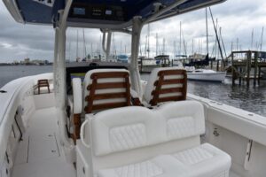 2027 Jupiter 34 center console cockpit and helm area with forward console seating and hardtop overhead, docked in South Da...