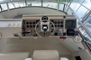 Carver 406 Aft Cabin Motor Yacht helm station with dual helm seats, steering wheel, and instrument panel.