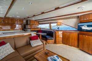 Bertram 510 Convertible helm station with dual Garmin displays, leather helm chair, and teak accents in the pilothouse.
