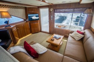 Bertram 510 Convertible helm station with dual Garmin displays, leather helm chair, and teak accents in the pilothouse.