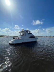 Carver 444 Cockpit Motor Yacht helm station with dual Garmin displays, leather helm chair, and forward salon visibility th...