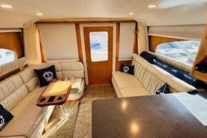 2001 Luhrs 40 Convertible helm station with dual Garmin displays, leather helm seat, and forward salon visibility through ...