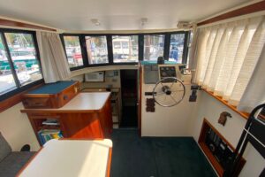 Camano 30 cabin cruiser helm station with dual helm seats, steering wheel, and forward windshield view.
