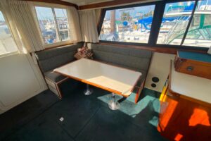 Camano 30 cabin cruiser helm station with dual helm chairs, steering wheel, and forward windshield view.