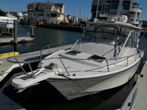 Grady-White Express 330 center console helm station with dual Garmin displays, steering wheel, and throttle controls.