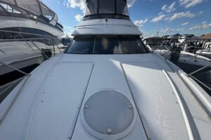 Carver 444 Cockpit Motor Yacht helm station with dual helm seats, steering wheel, and instrument panel displaying navigati...