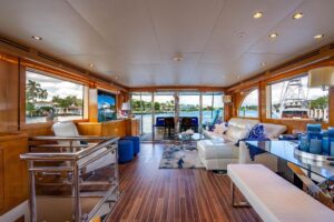 Hatteras 75 Cockpit Motor Yacht helm station with dual Garmin displays, leather helm chair, and teak accents in the piloth...
