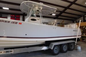 Regulator 32 center console helm station with dual Garmin displays, steering wheel, and throttle controls.