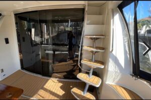 Carver 56 Voyager salon with cream upholstered seating, entertainment center, and natural lighting from cabin windows.
