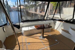 Carver 56 Voyager pilothouse salon with forward-facing windows, upholstered seating, and cabin entry door.