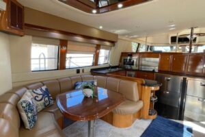 Carver 56 Voyager pilothouse salon with forward-facing windows, upholstered seating, and overhead lighting.