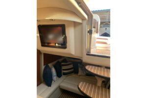 2005 Sea Ray 340 Sundancer salon with curved seating, entertainment center, and cabin access in Pass Christian, MS.