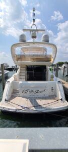 Viking Princess 61 Flybridge flybridge helm station with dual helm chairs, steering wheel, and panoramic windscreen overlo...