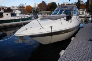 Helm station of 2007 Cruisers 340 Express with dual helm seats, steering wheel, throttle controls, and Garmin electronics ...