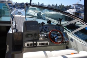 Helm station of 2007 Cruisers 340 Express with dual helm seats, center console steering, and forward windshield view towar...