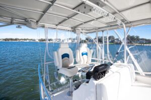 Luhrs 36 Convertible helm station with dual Garmin displays, leather helm chair, and center console steering wheel.