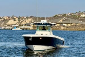 Everglades 350 center console helm station with dual Garmin displays, steering wheel, and throttle controls overlooking th...