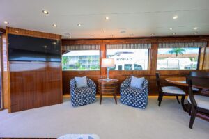 72-foot Hatteras Enclosed Bridge yacht helm station with dual Garmin displays, leather captain's chair, and enclosed bridg...