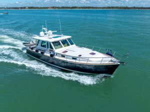 Sabre 52 Express helm station with dual Garmin displays, leather helm chair, and forward salon visibility through windshield.