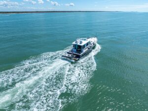 Sabre 52 Express salon with cream upholstered seating, teak accents, and natural lighting from cabin windows.