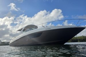 2010 Sea Ray Sundancer 370 salon with curved seating, entertainment center, and cabin access in Aventura, Florida.