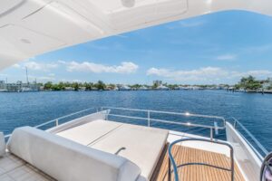Azimut 64 flybridge with helm station, hardtop, and forward seating overlooking the bow.