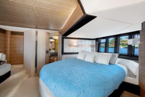2013 Azimut 64 salon with cream upholstered seating, teak flooring, and large windows overlooking the water.