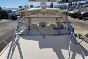 Grady-White Express 330 helm station with dual Garmin displays, stainless steel wheel, and forward visibility through wind...