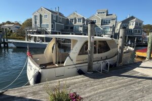 Greenline 33 cabin cruiser helm station with dual helm seats, steering wheel, and forward windshield view in pilothouse.