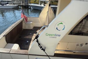 Greenline 33 cabin cruiser helm station with dual displays and steering wheel in pilothouse.