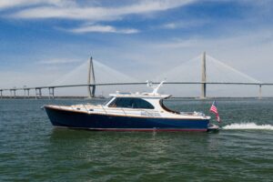 2015 Hinckley Talaria 43 motor yacht profile showing classic design with hardtop, teak accents, and twin outboard engines ...
