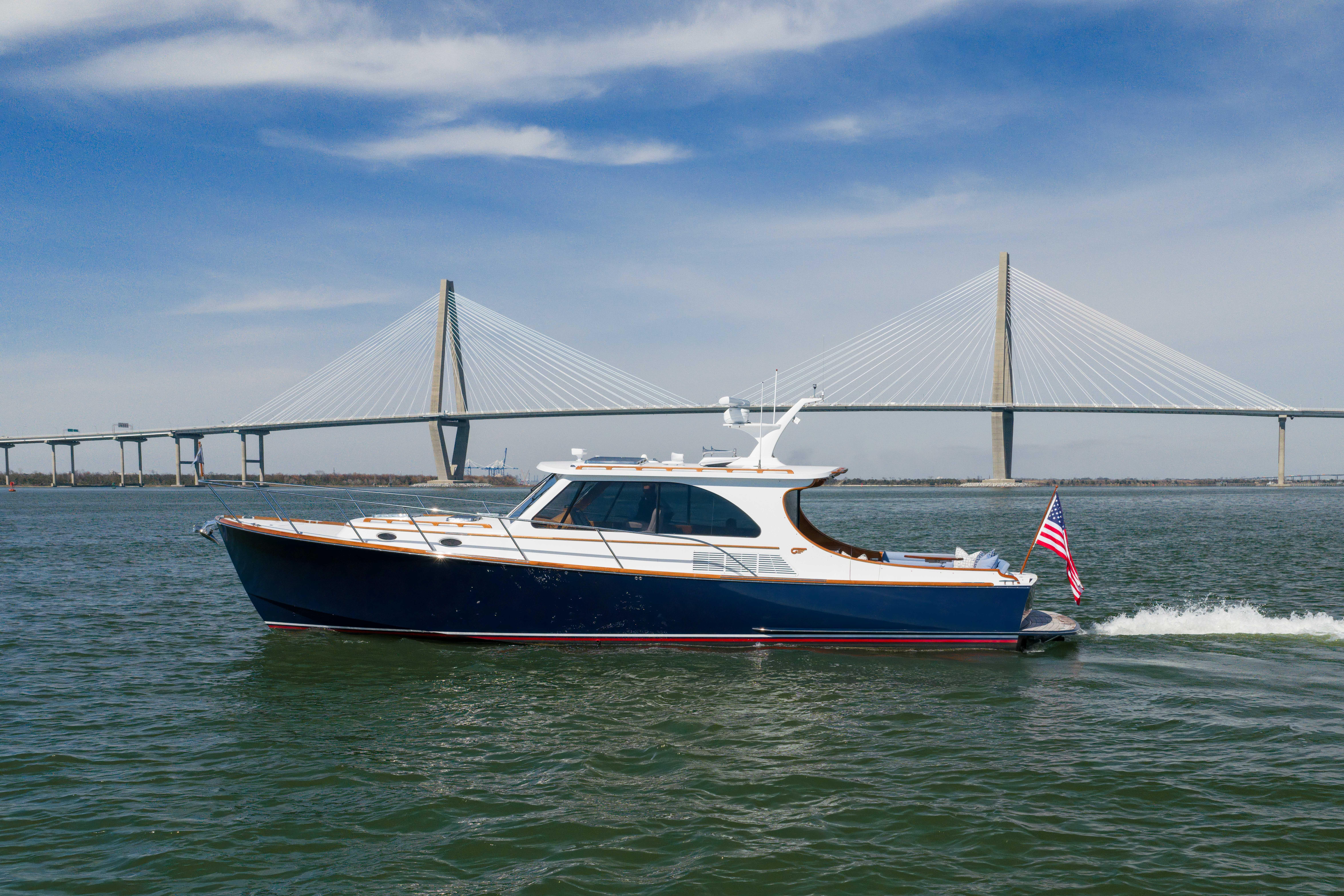 2015 Hinckley Talaria 43 motor yacht profile showing classic design with hardtop, teak accents, and twin outboard engines ...