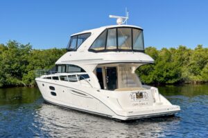 Helm station of 2015 Meridian 441 Sedan with dual helm chairs, Garmin electronics displays, and forward cabin visibility t...