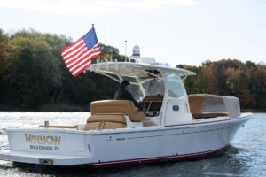 2016 Hunt Yachts 32 center console with hardtop and outboard engines, starboard profile view.