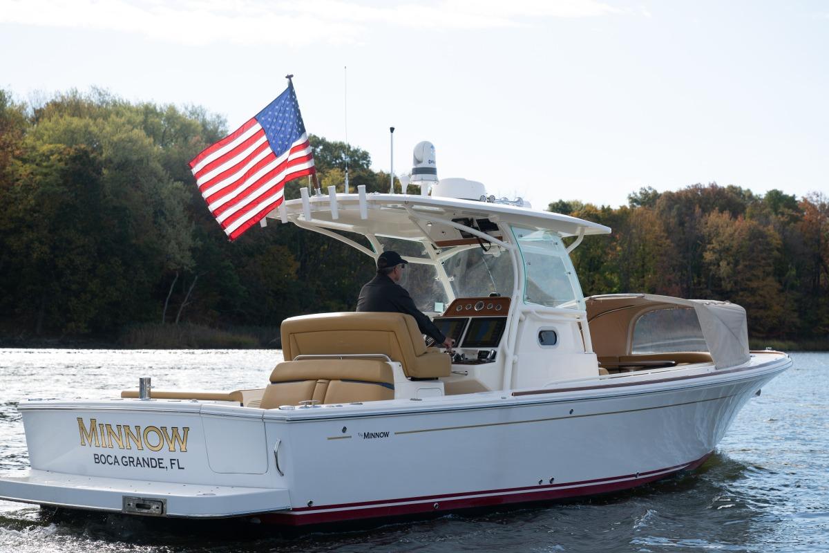 2016 Hunt Yachts 32 center console with hardtop and outboard engines, starboard profile view.