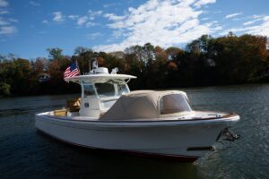 Hunt Yachts 32 center console helm station with dual Garmin displays, steering wheel, and throttle controls overlooking th...
