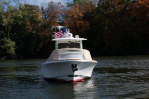 Helm station of 2016 Hunt Yachts 32 center console with dual Garmin displays, steering wheel, and overhead hardtop.