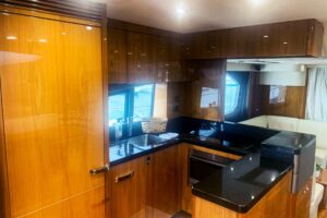 2016 Sunseeker Manhattan 65 salon with cream upholstery, curved seating, entertainment center, and natural light from larg...