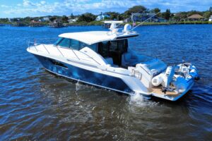 Tiara Yachts C44 Coupe helm station with dual Garmin displays and leather helm seating in the pilothouse.
